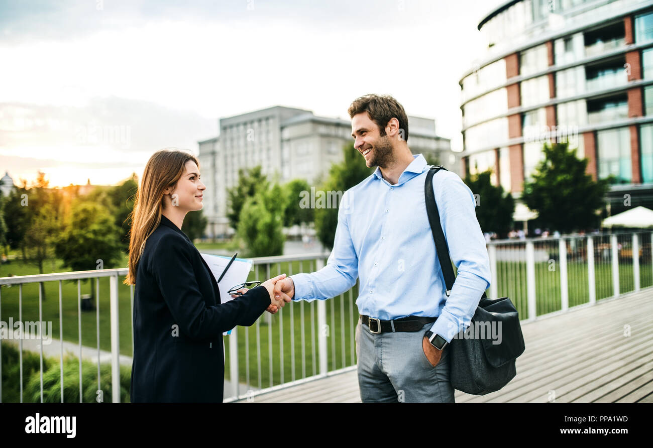 Young businessman and businesswoman shaking hands outdoors Stock Photo ...