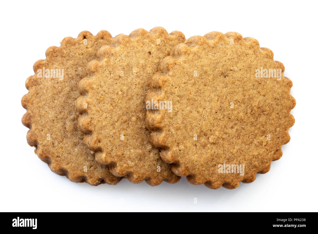 Three round gingerbread biscuits isolated on white from above. Serrated edge. Stock Photo