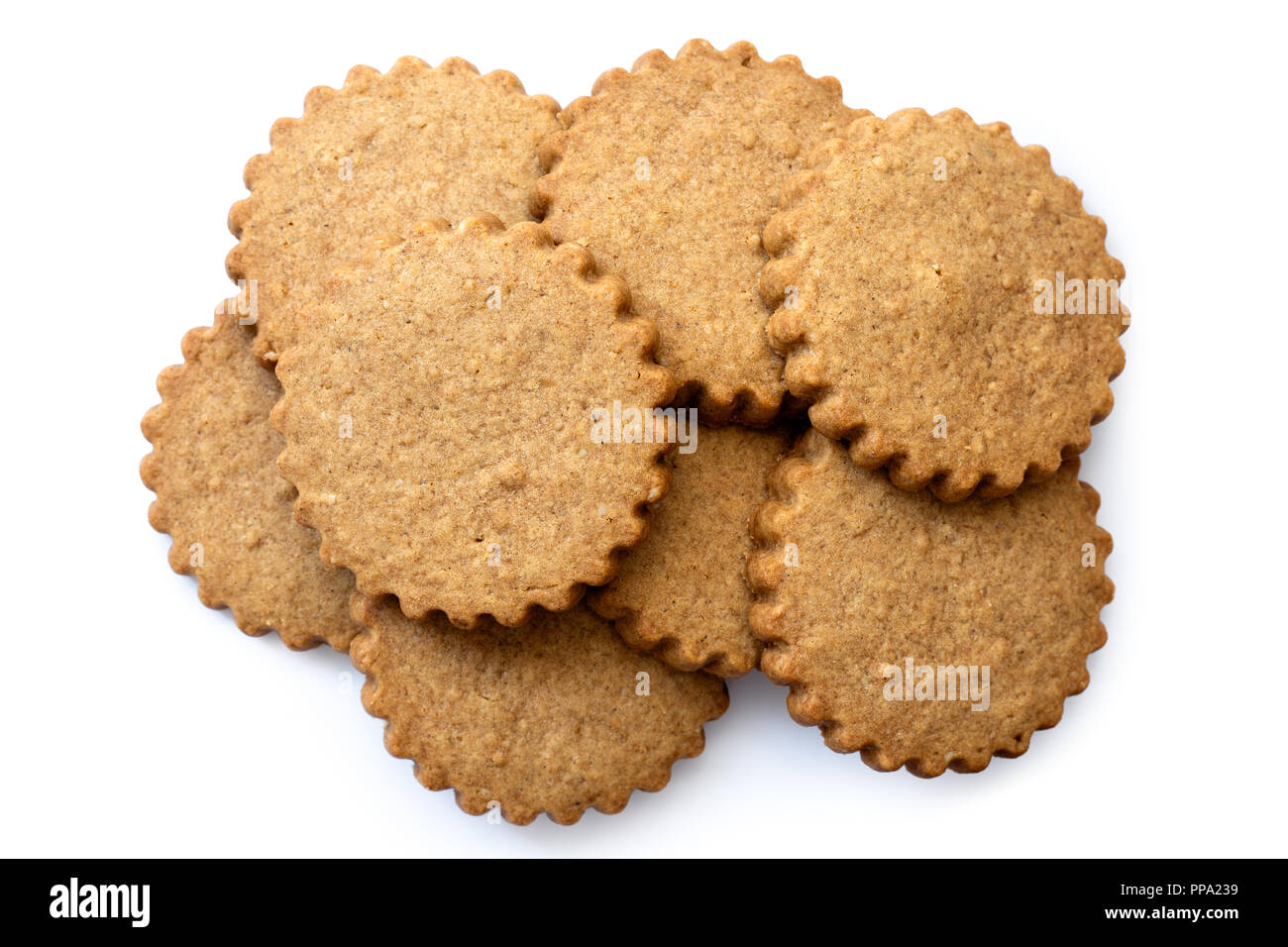 A pile of round gingerbread biscuits isolated on white from above. Serrated edge. Stock Photo
