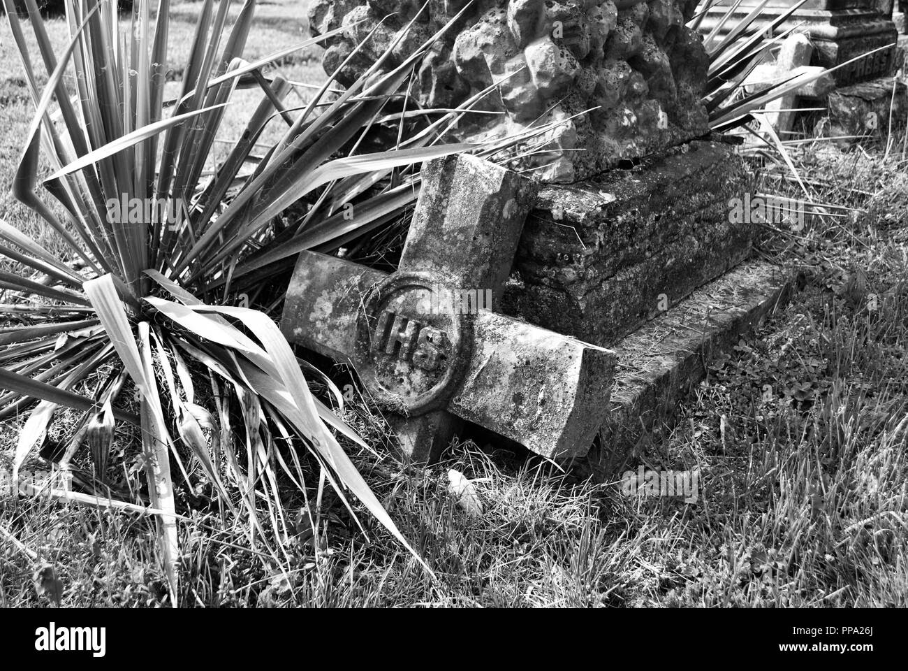 very old moss covered broken statue / headstone in a cemetery Stock Photo