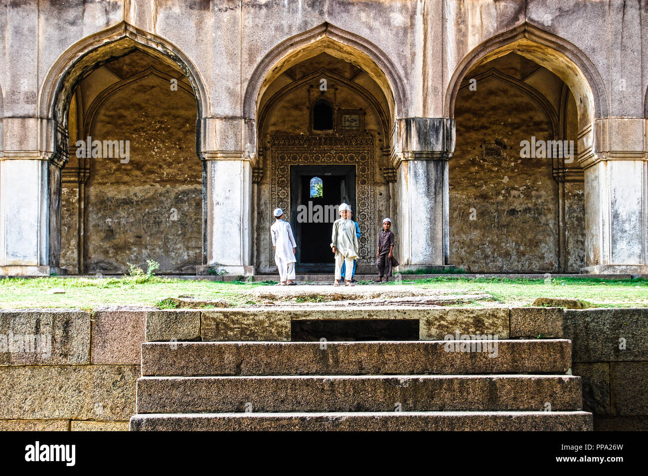 Traditionally dressed young Muslim boys exploring Qutb Shahi Tombs. Hyderabad, India - July 10, 2014 Stock Photo