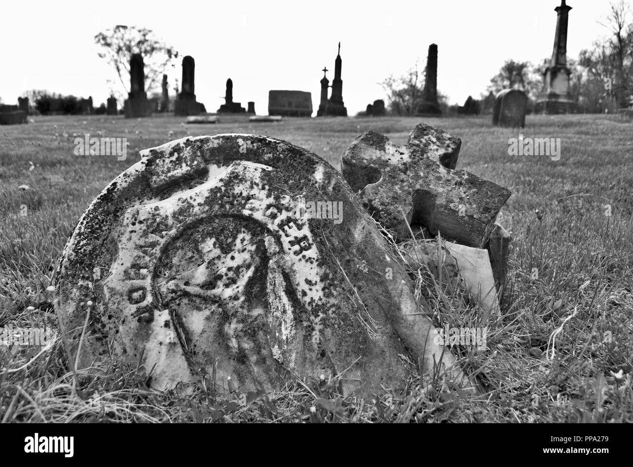 very old moss covered broken statue / headstone in a cemetery Stock Photo