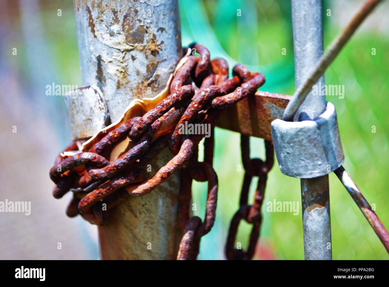 rust covered lock on chain link fence Stock Photo