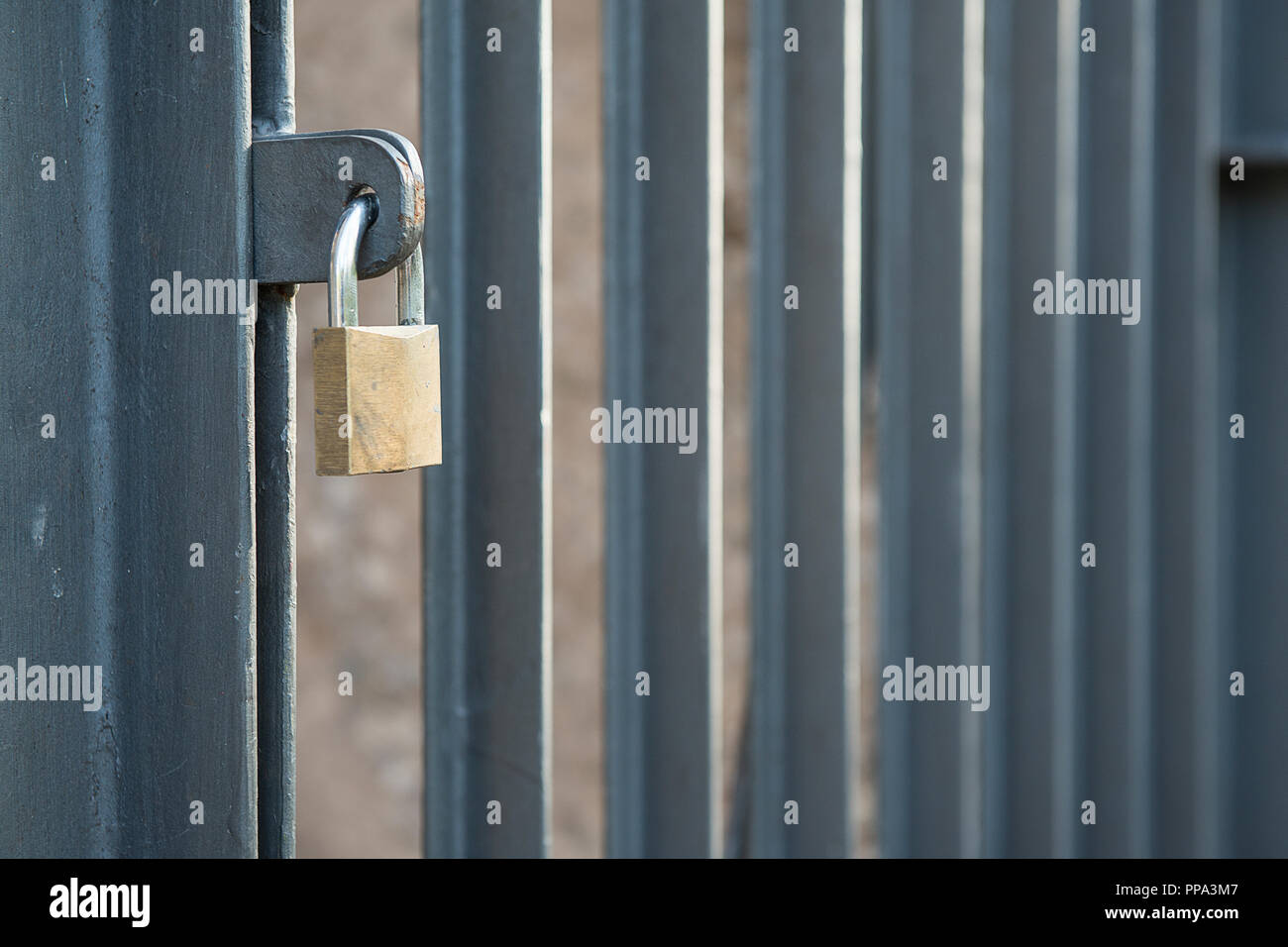 Closed padlock on a Closed gate with vertical bars Stock Photo - Alamy
