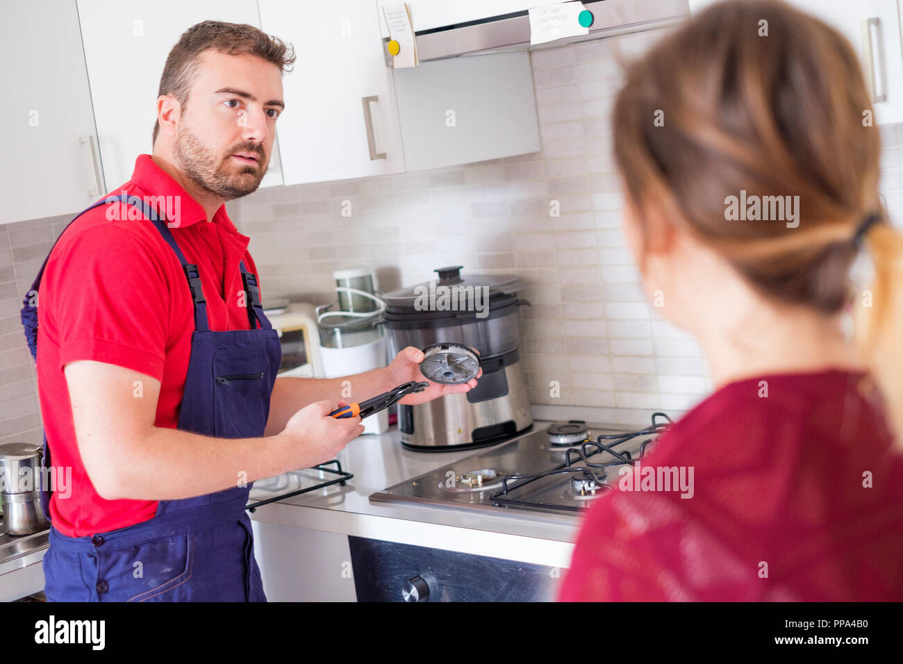 Handyman fixing gas stove in the kitchen Stock Photo Alamy