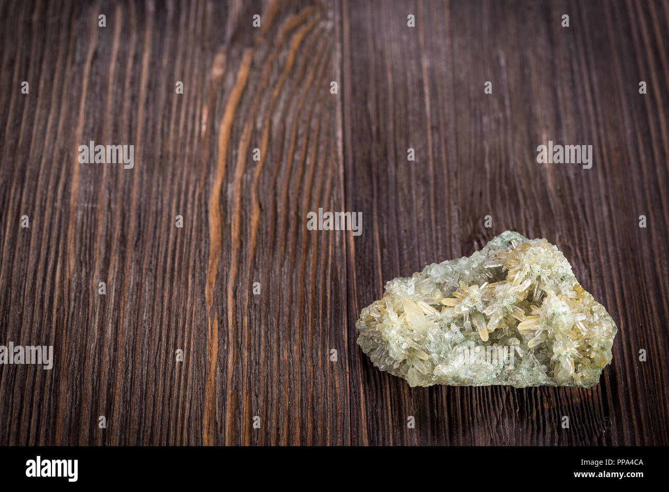 Druse green crystals of quartz on a dark wooden background Stock Photo