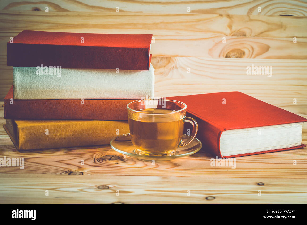 Glass Cup With Tea And A Stack Of Books With Colorful Covers