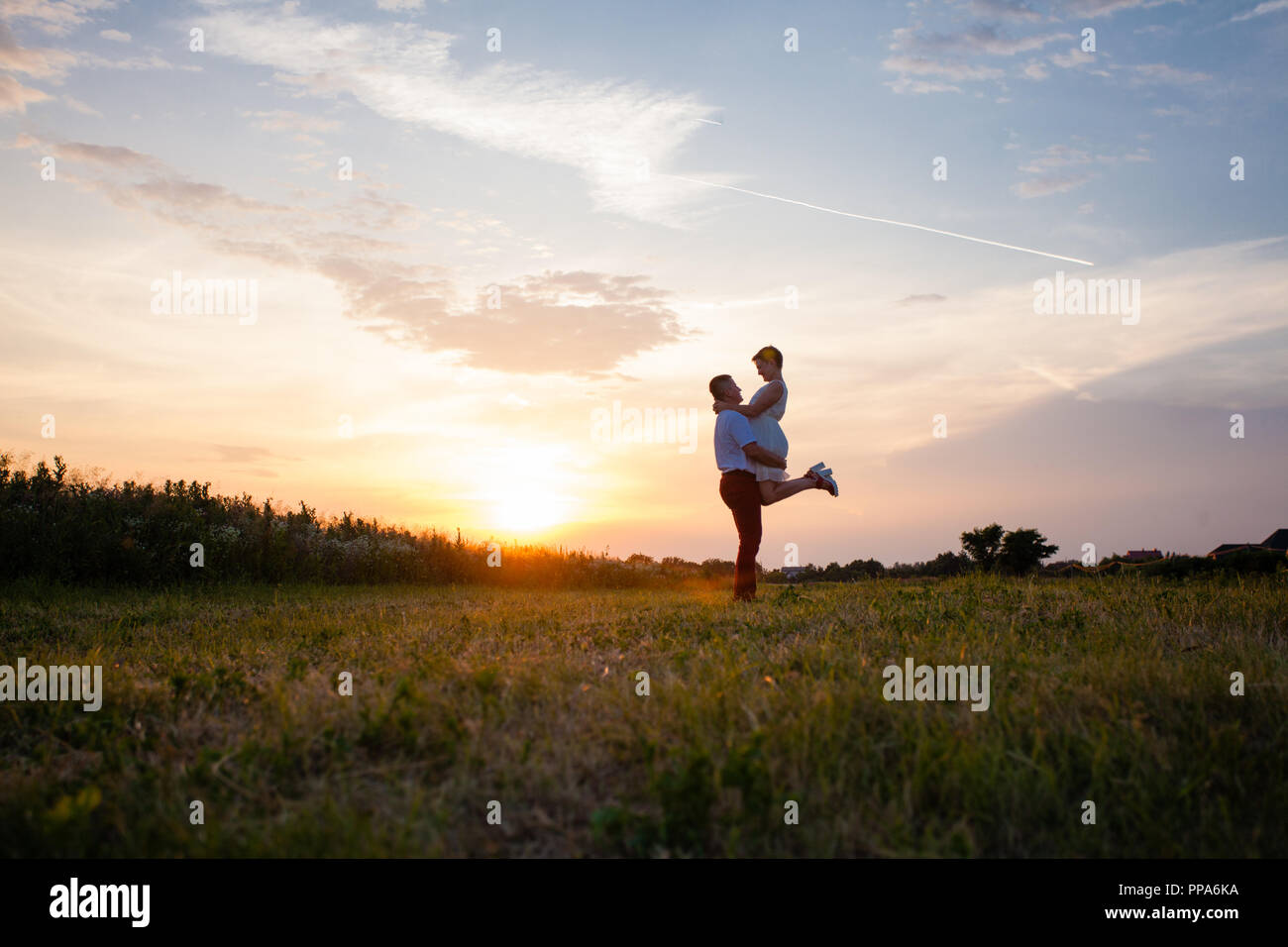 Rustic wedding couple at sunset in the summer outdoors Stock Photo