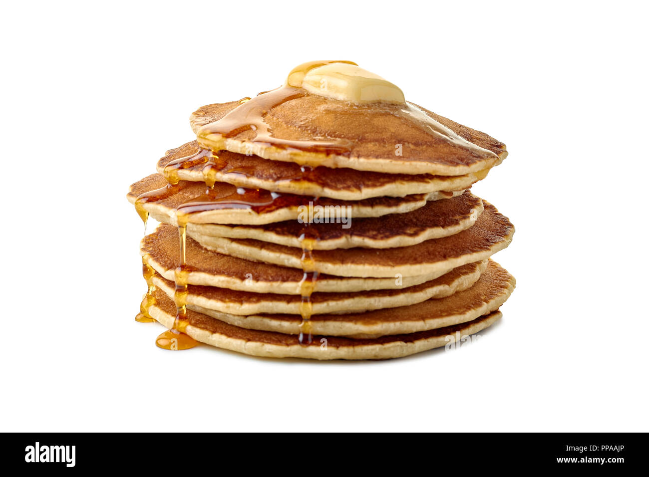 Stack of pancakes with butter and a flowing maple syrup on white Stock