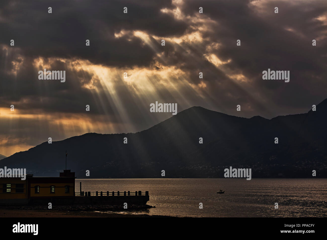 Rays of Sun through the clouds on the lake at the end of the autumn day Stock Photo