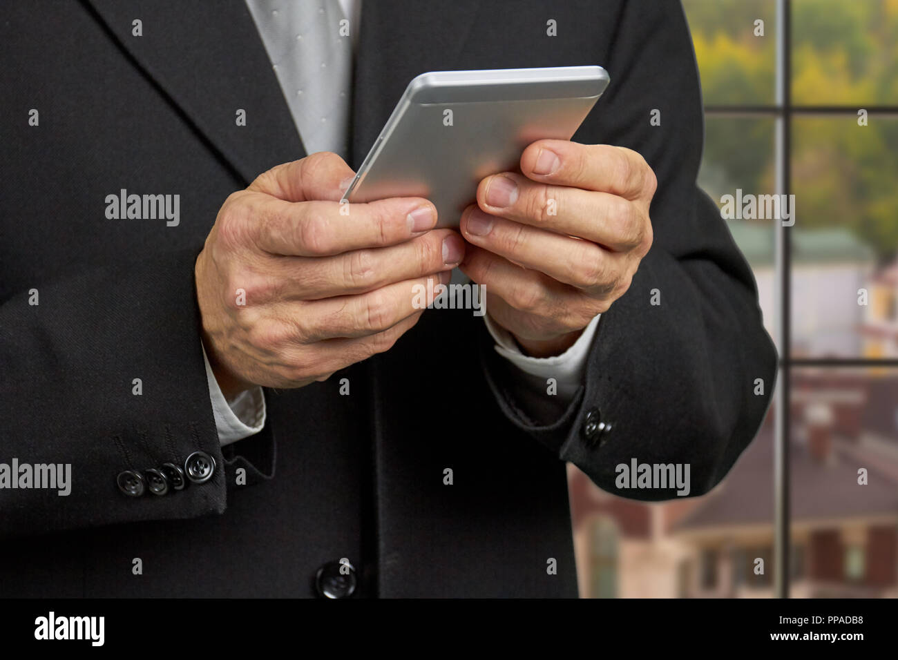 Close up businessman reading news on smartphone. Stock Photo