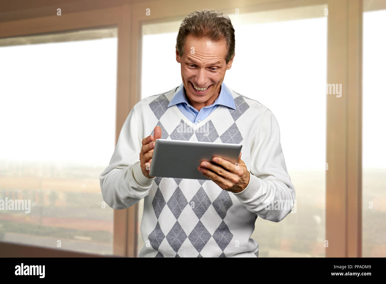 Portrait of joyful man talking using tablet. Stock Photo