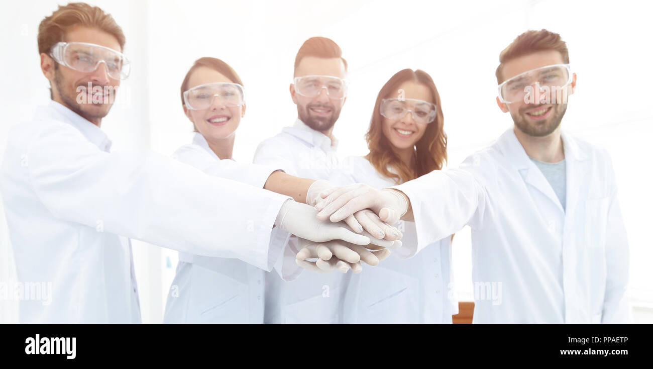 successful team of young scientists with hands clasped together Stock ...