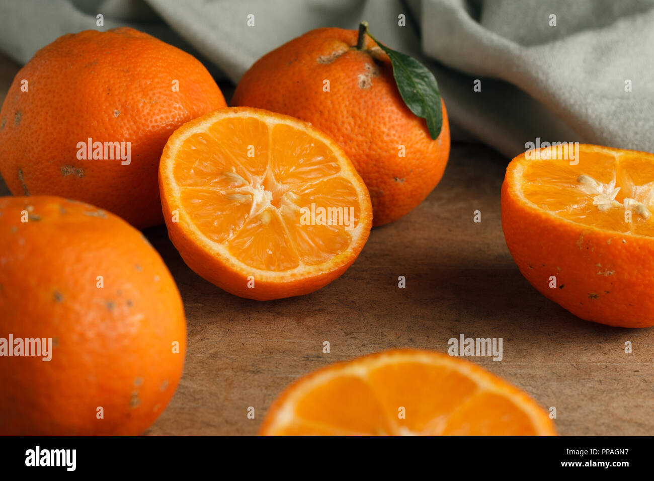 Closeup on a half sliced Rangpur lime surrounded by others; selective focus. Stock Photo