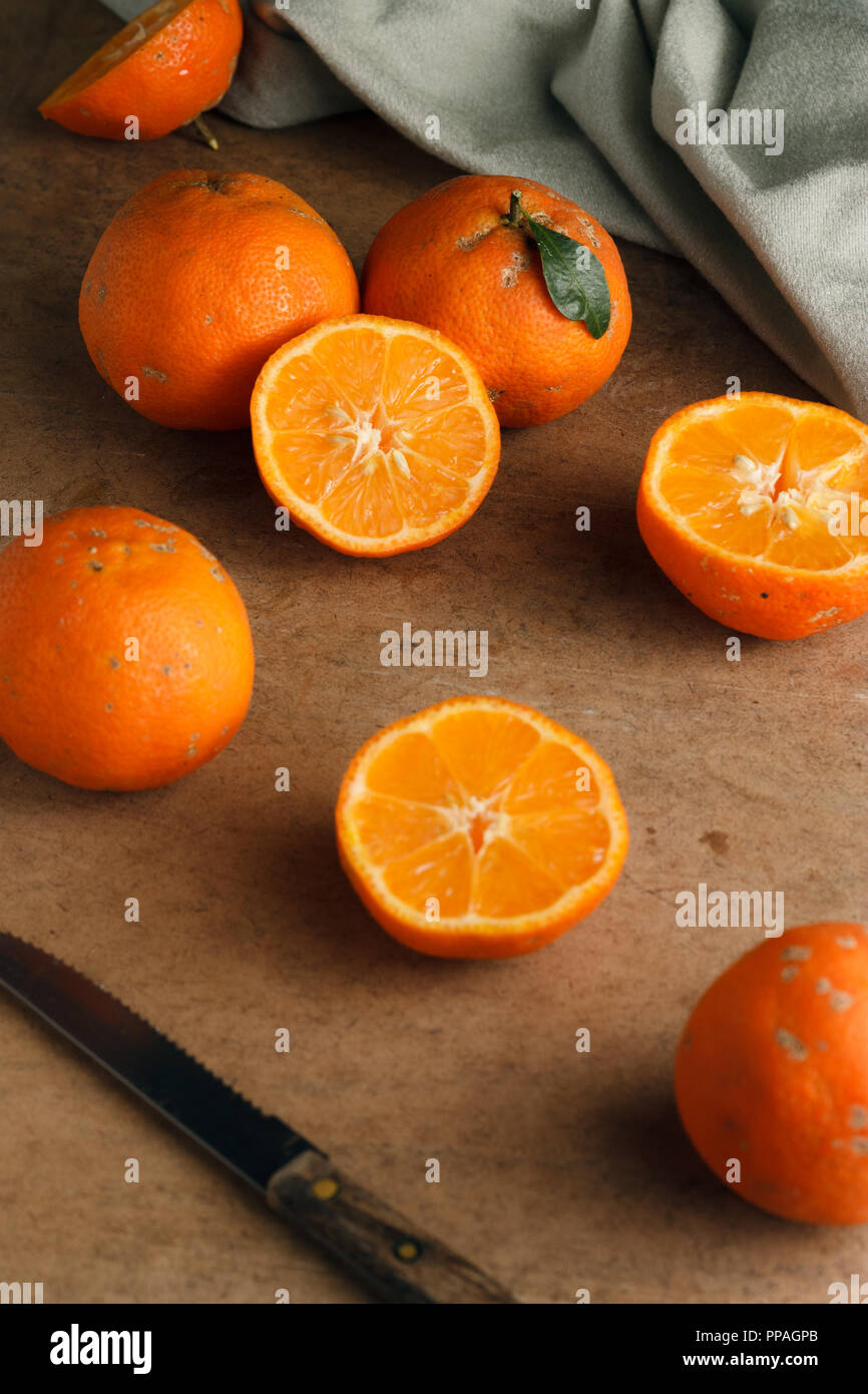 Group of juicy ripe Rangpur limes spread on a wooden table; selective focus. Stock Photo