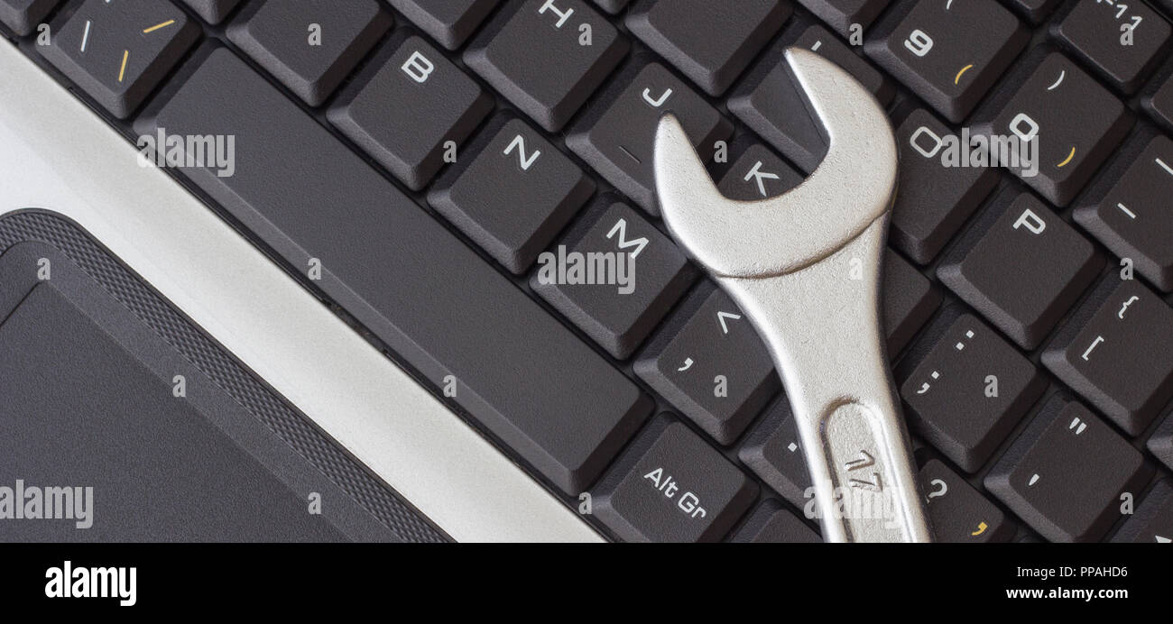 Spanner on the laptop keyboard, the concept of repairing machinery, close-up Stock Photo