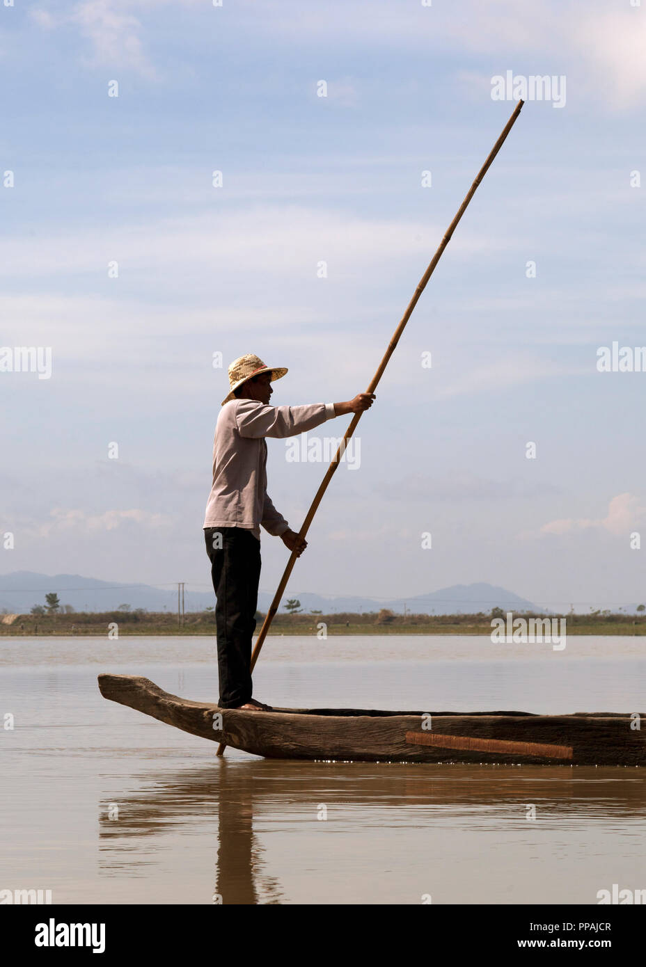 Dak Lak, VIETNAM - JANUARY 6, 2015 - Man pushing a boat with a pole Stock Photo