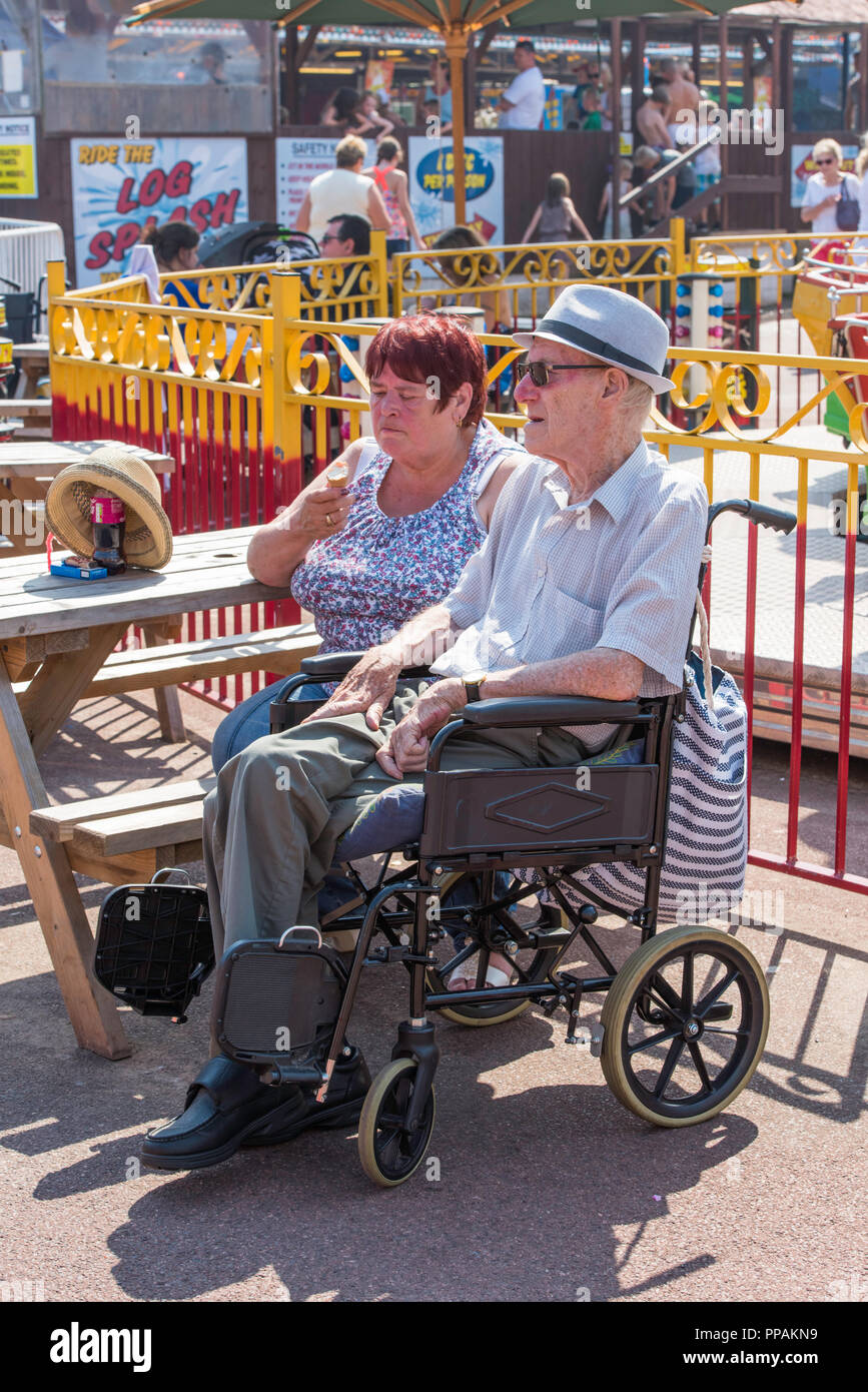 Man in a wheelchair with a woman in the amusement park in Dymchurch ...