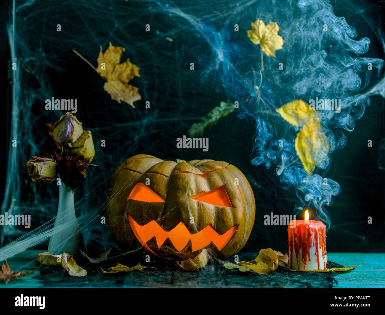 Halloween photo of table with pumpkin, burning candle, cobweb Stock ...