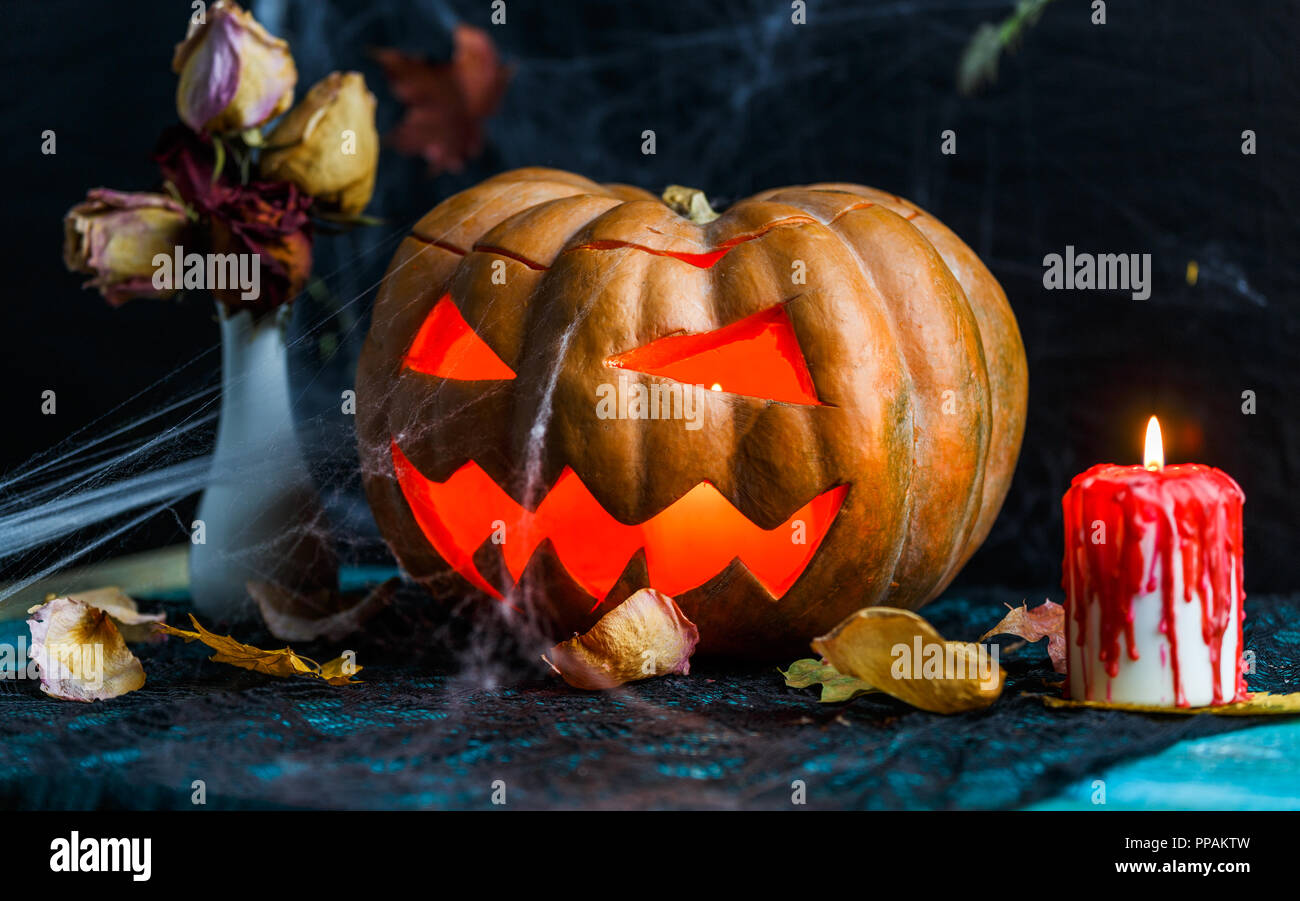 Halloween picture of table with pumpkin, burning candle Stock Photo - Alamy
