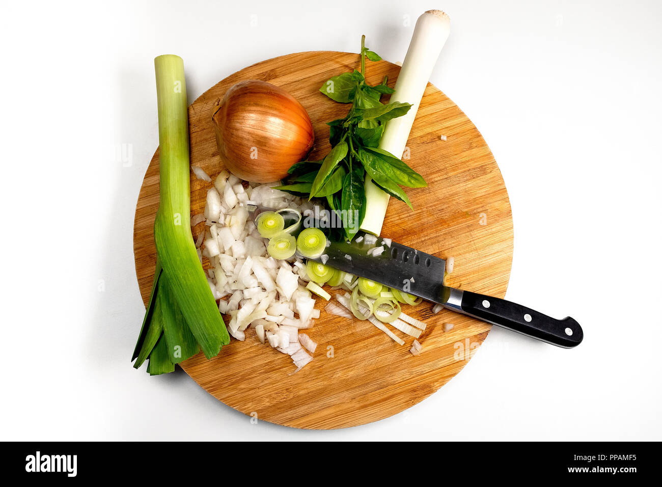 leek, onion and basil over a cutting board, during cooking time. Stock Photo