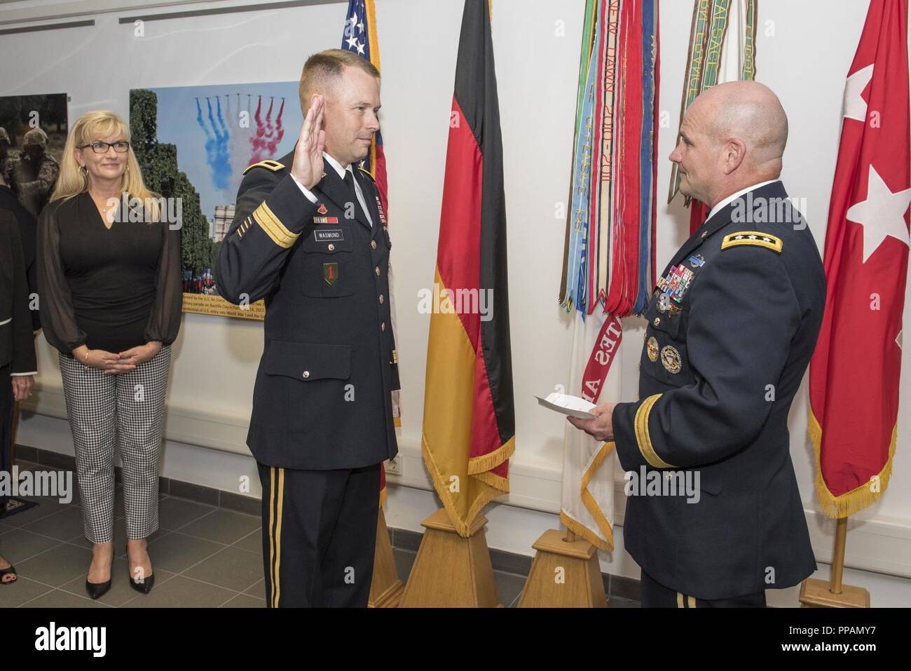 Lt. Gen. Christopher Cavoli, right, commanding general of U.S. Army Europe, administers the Oath of Office to newly promoted Brig. Gen. Todd Wasmund, left, the deputy commanding general (DCG) of the U.S. Army Europe Mission Command Element and DCG for support for the 1st Infantry Division, while his wife, Tracy Wasmund, far left, looks on during Wasmund’s promotion ceremony held at the U.S. Army Europe headquarters in Wiesbaden, Germany, Sept. 4, 2018. Stock Photo