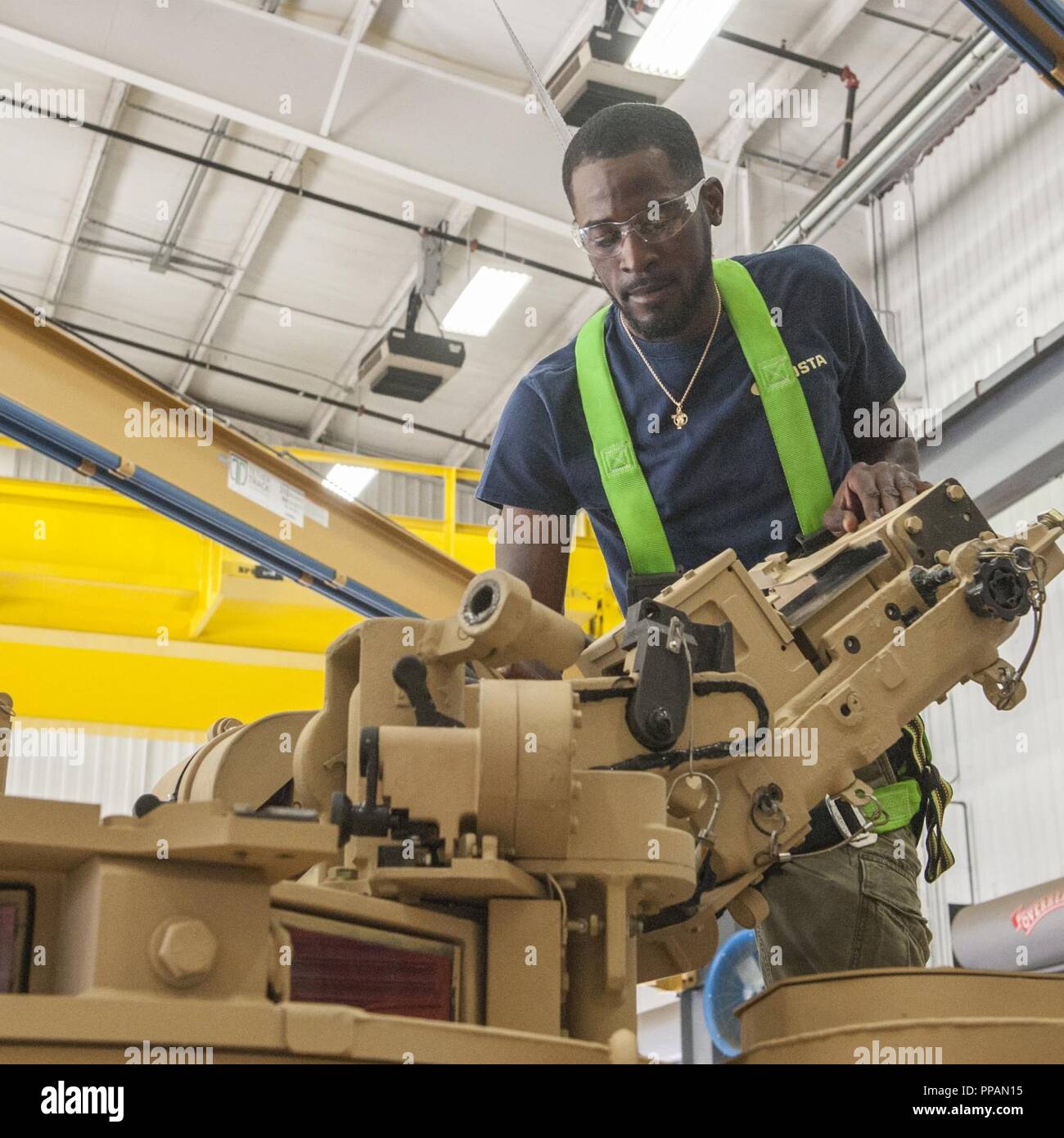 Ashton Cohill performs an inspection of turret components as part of a ...