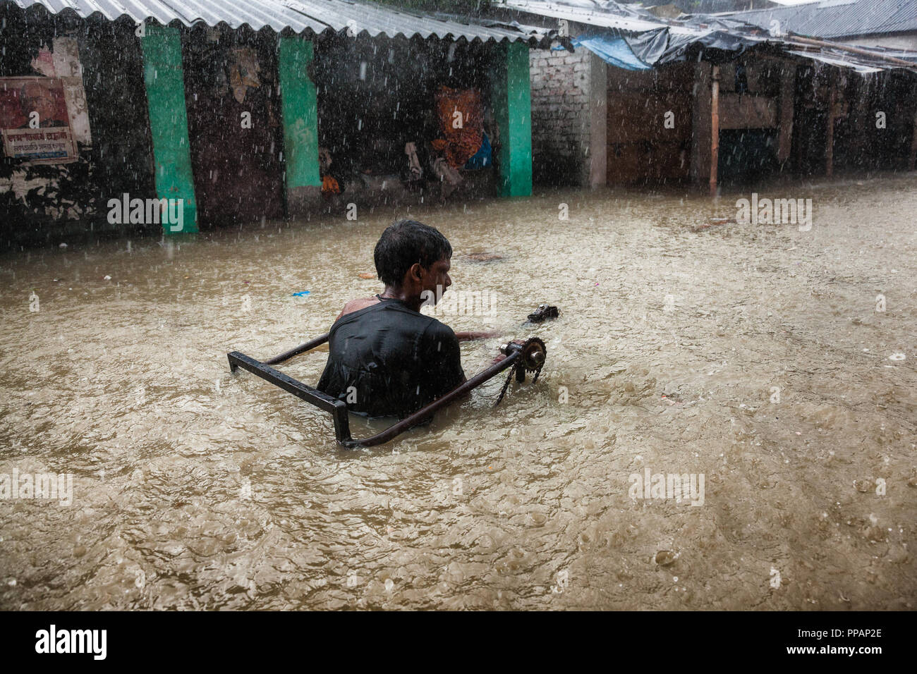 A man in manual chain pulled wheelchair tries to cross a heavily ...