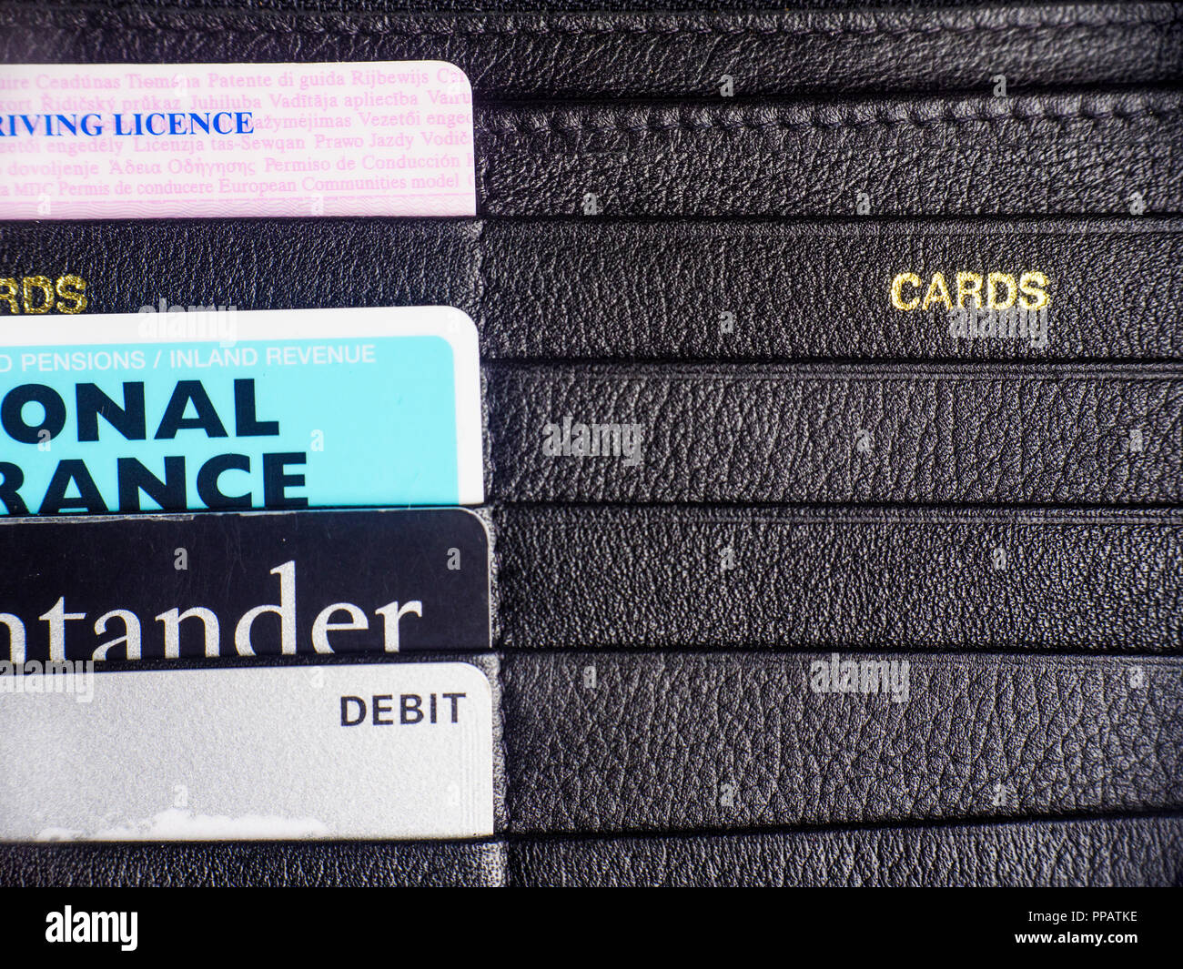 Assorted plastic cards filed in a black leather wallet. Stock Photo