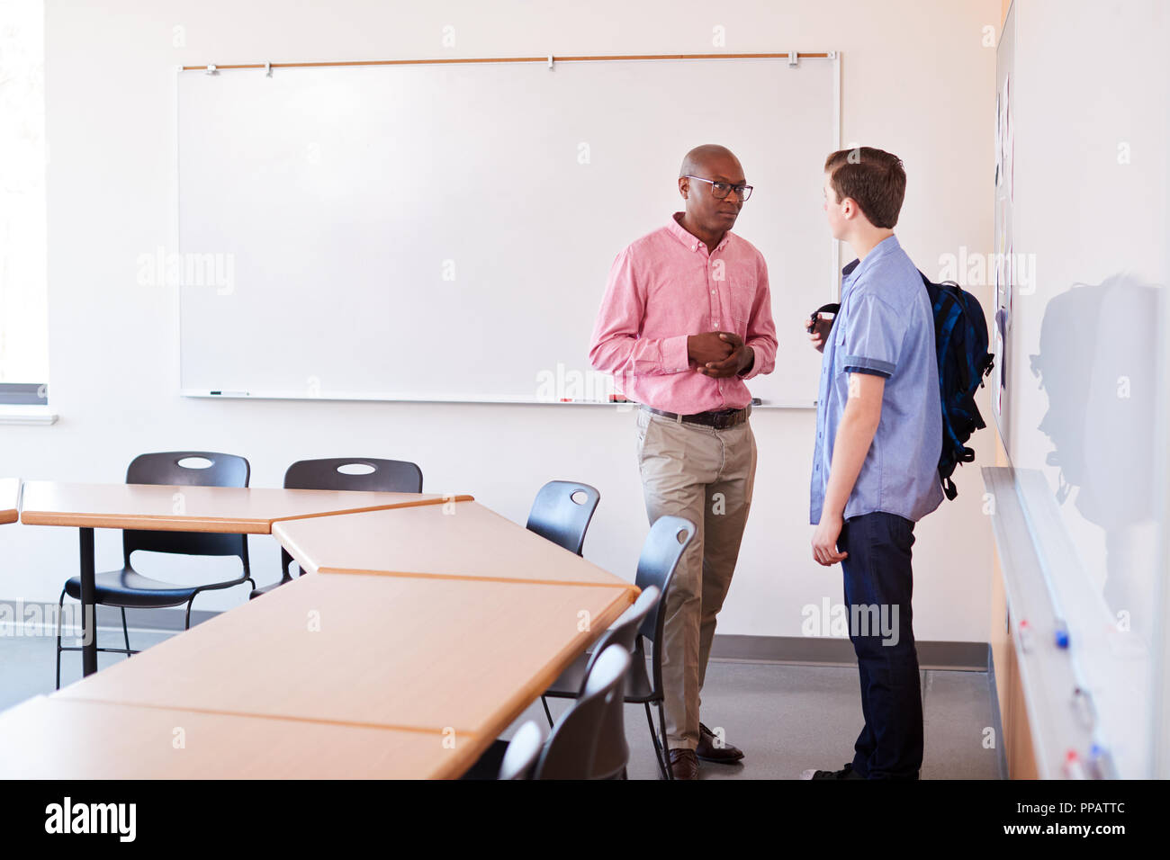 High School Tutor Talking With Male Student After Class Stock Photo