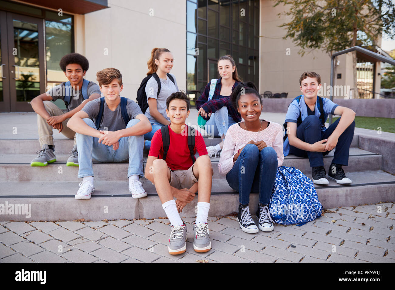 Portrait Of High School Student Group Sitting Outside College Buildings Stock Photo