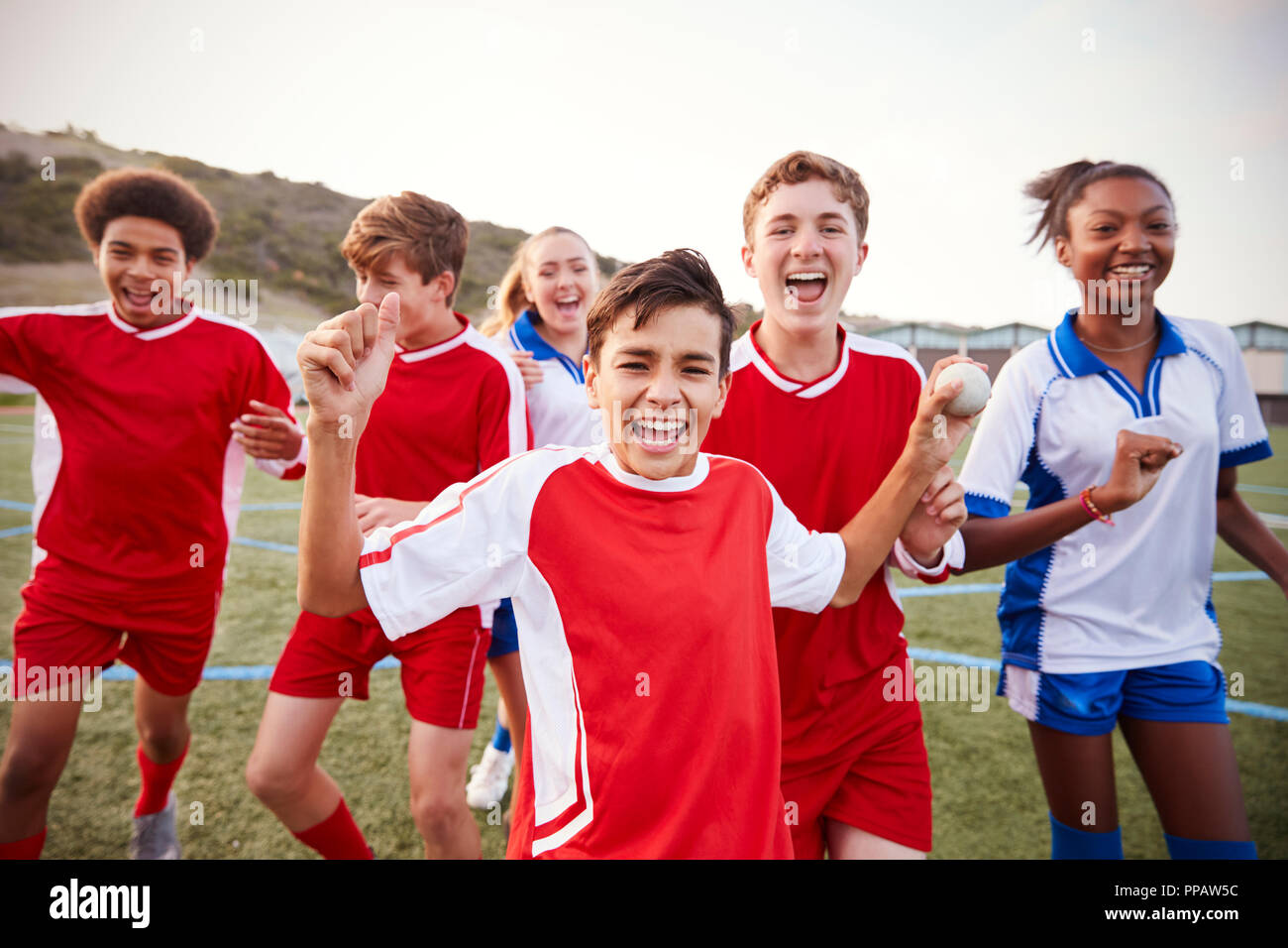 Portrait Of Male And Female High School Soccer Teams Celebrating Stock Photo
