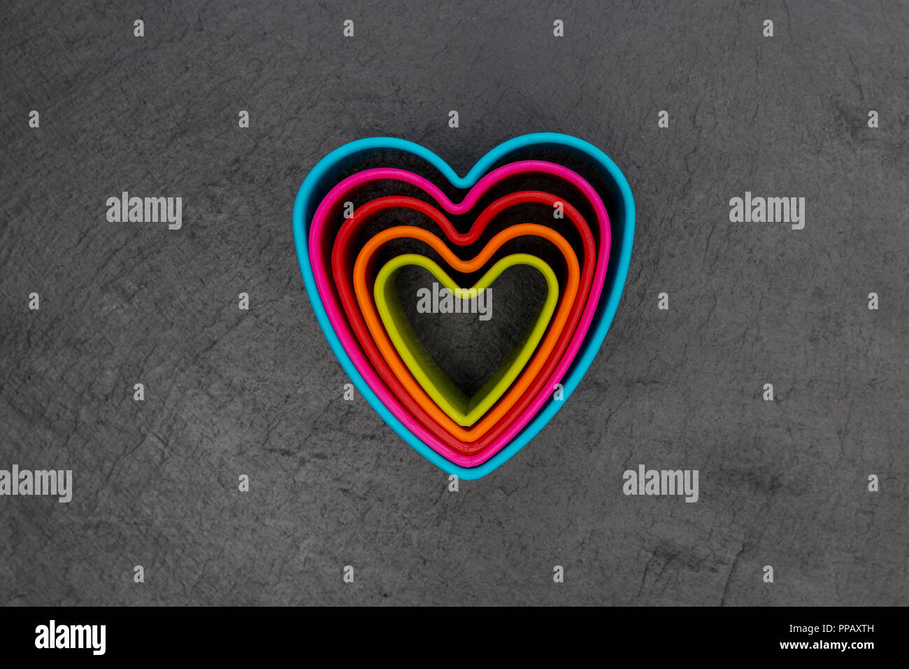 Cookie cutter love heart shape on dark background Stock Photo
