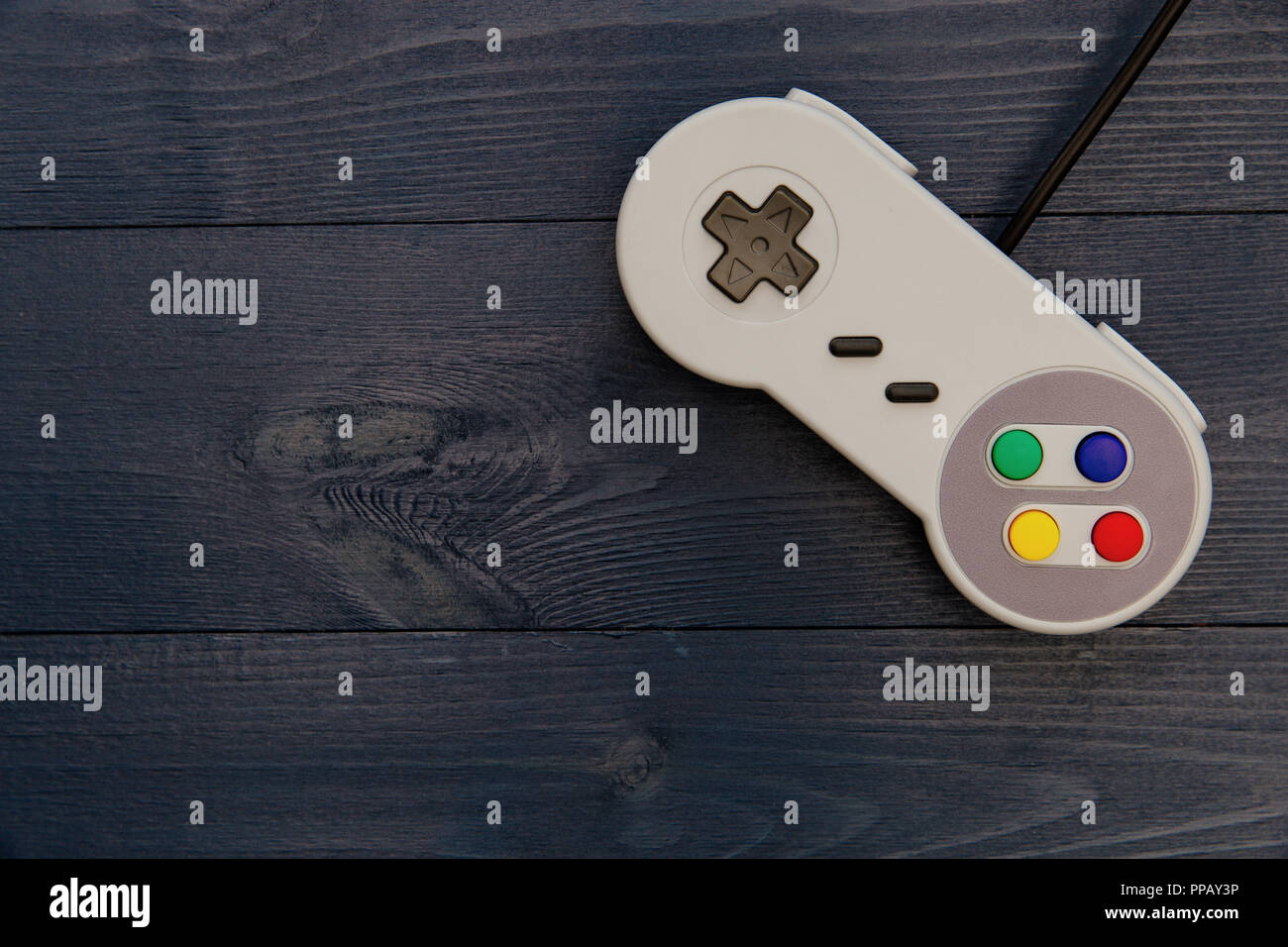Retro video game controller dark table background Stock Photo