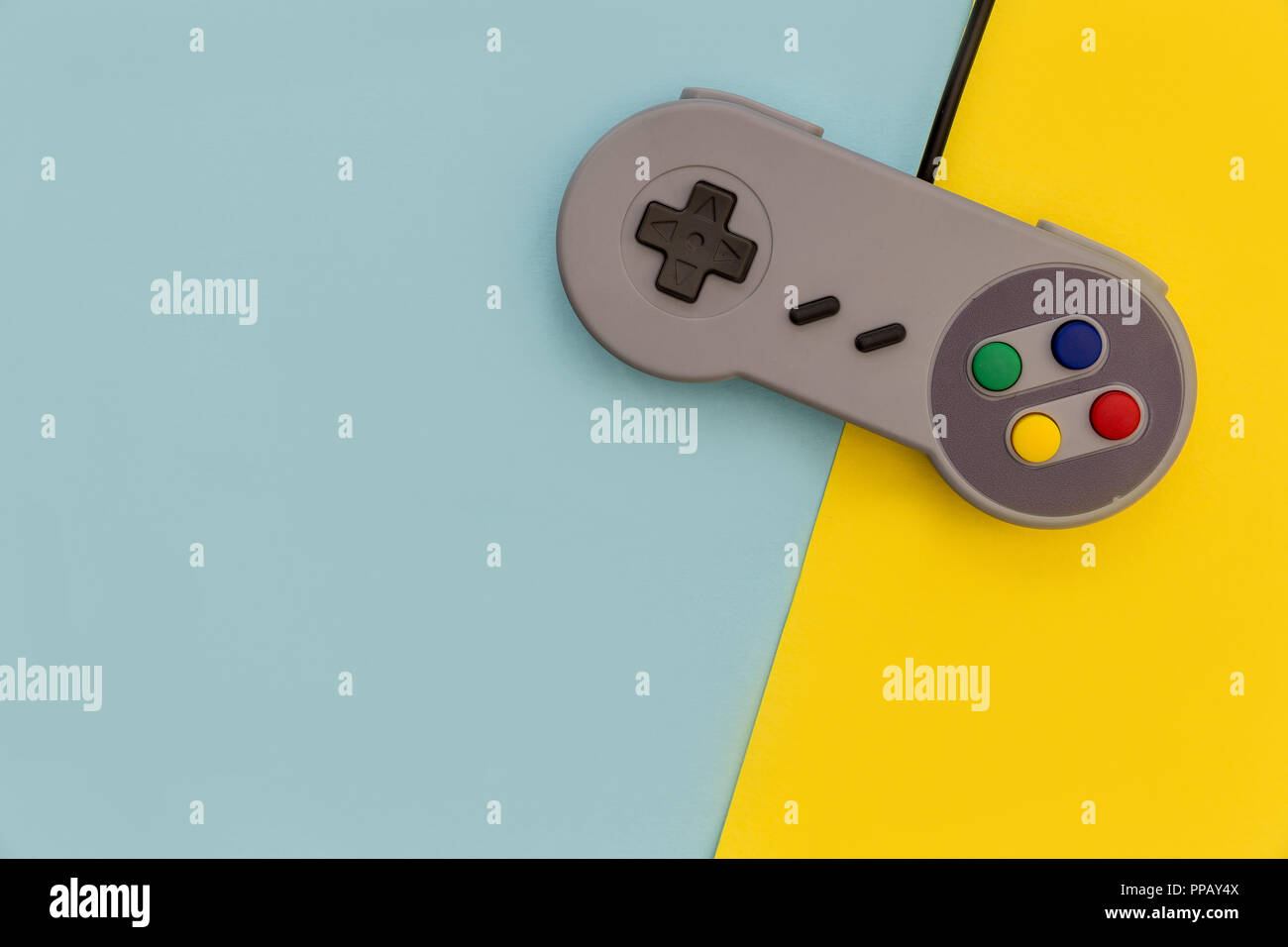 Retro video game controller on yellow blue background Stock Photo - Alamy