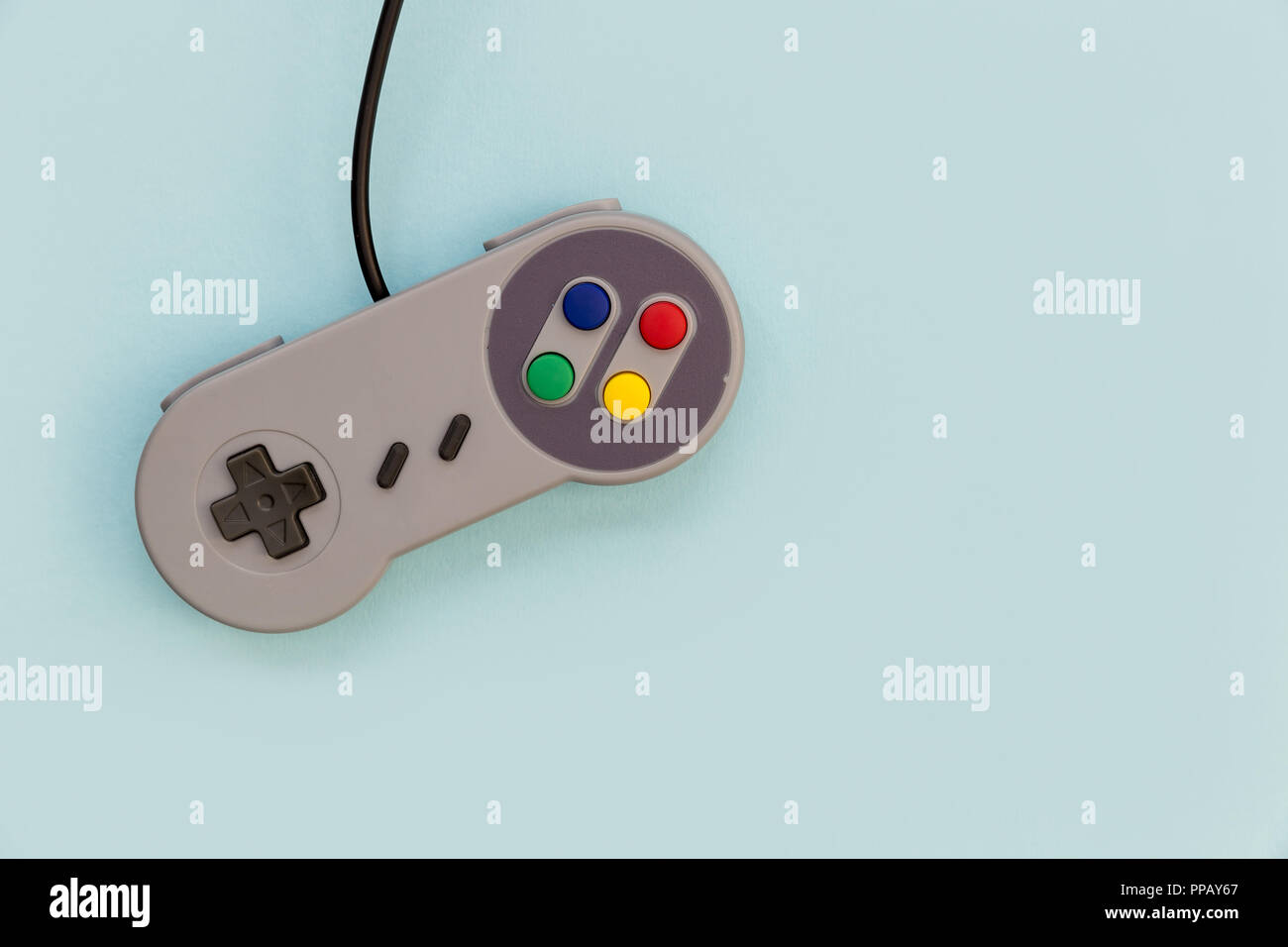 Retro video game controller on blue background Stock Photo