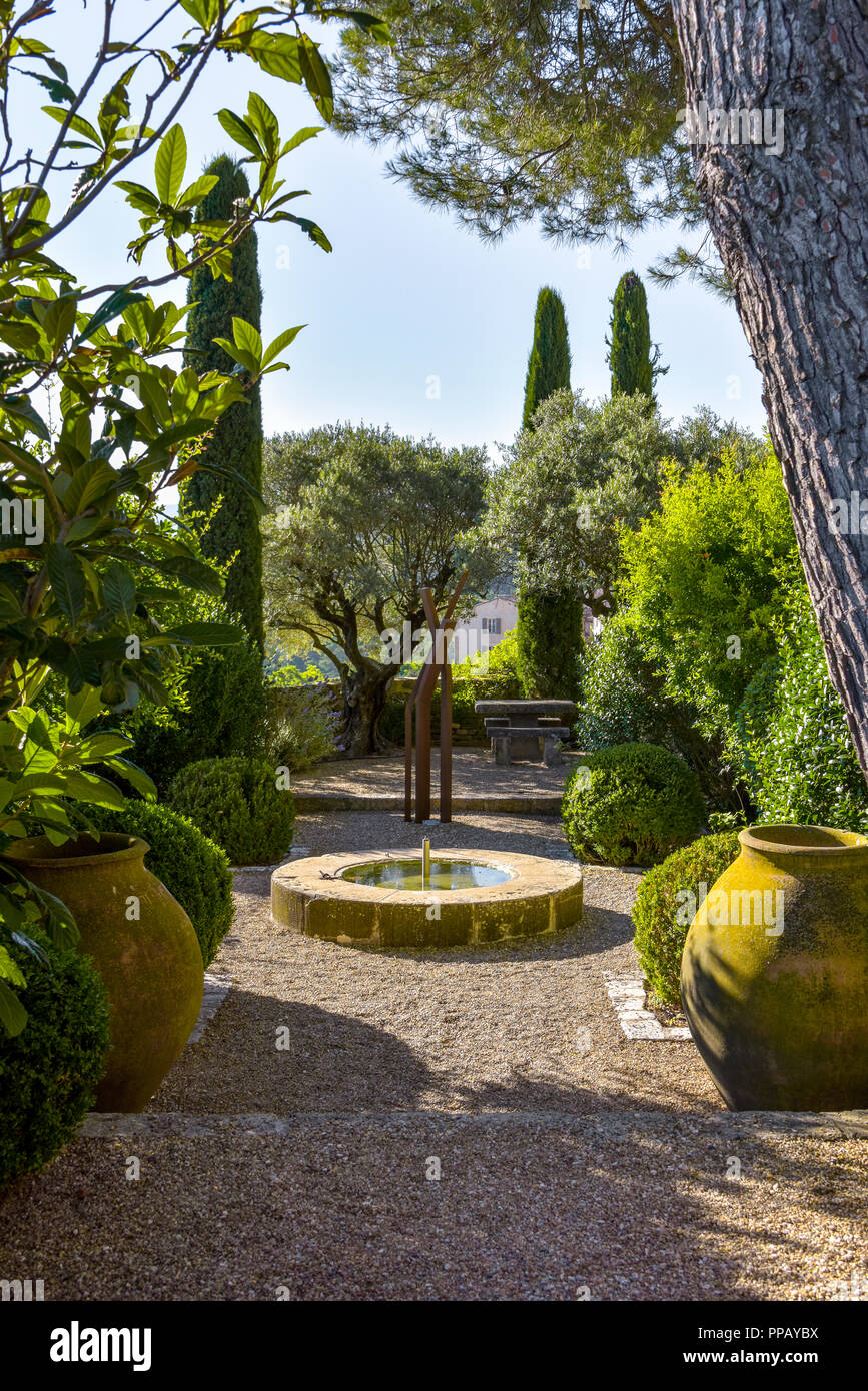 small garden in the Provence with fountain and amphores, old village Ménerbes, France, situated on a hill, department Vaucluse, Luberon mountains Stock Photo