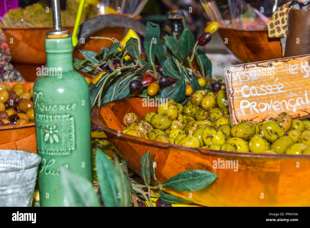 presentation of regional products, olives with herbs and olive oil of the Provence, decoration with olive branches, Riez, France, street market Stock Photo