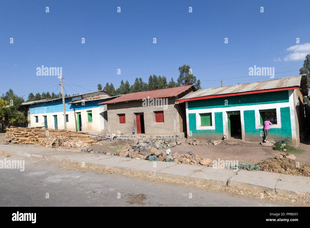 Village homes with shop right, Amhara Region, Ethiopia, Homes with Eucalyptus tree wood pile Stock Photo