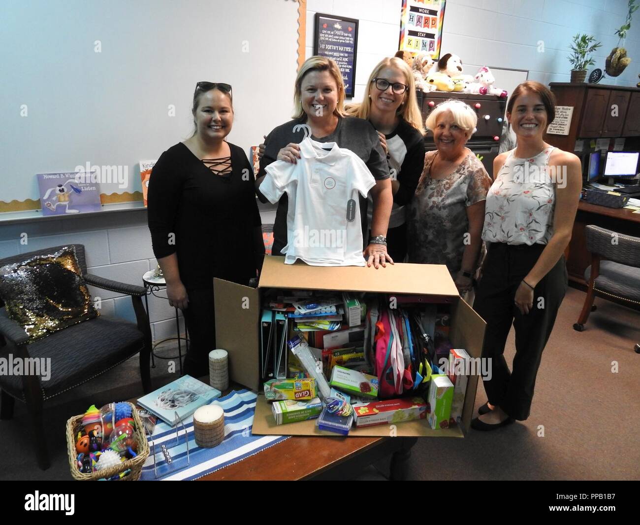 PANAMA CITY, Florida - Deniece Moss (center), principal at West Bay Elementary School poses with employees of Naval Surface Warfare Center Panama City Division’s (NSWC PCD) Test and Evaluation Prototype Fabrication Division. The group collected needed school supplies for Bay District School students in Panama City Beach, Florida August 13, 2018. Pictured from left to right: Nicole Waters, Deniece Moss, Michelle Armistead, Paula Oliver, and Halie Cameron. U.S. Navy Stock Photo