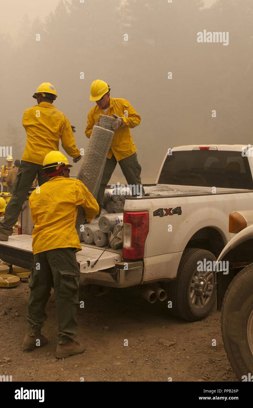 14th Brigade Engineer Battalion Soldiers from Joint Base Lewis-McChord, Washington load materials into a truck, August 13, 2018, in Mendocino National Forest, California. The service members are part of more than 200 active duty Soldiers from JBLM who traveled south to the Mendocino Complex Fire to support National Interagency Fire Center wildland fire fighting efforts. Stock Photo