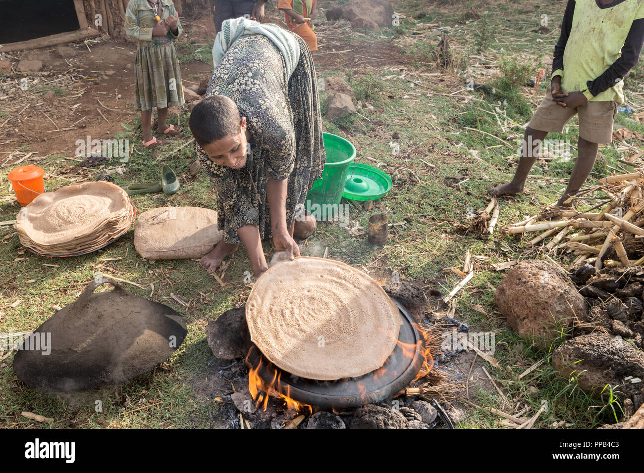 Tigray woman removing freshly prepared Injera made from Teff flour