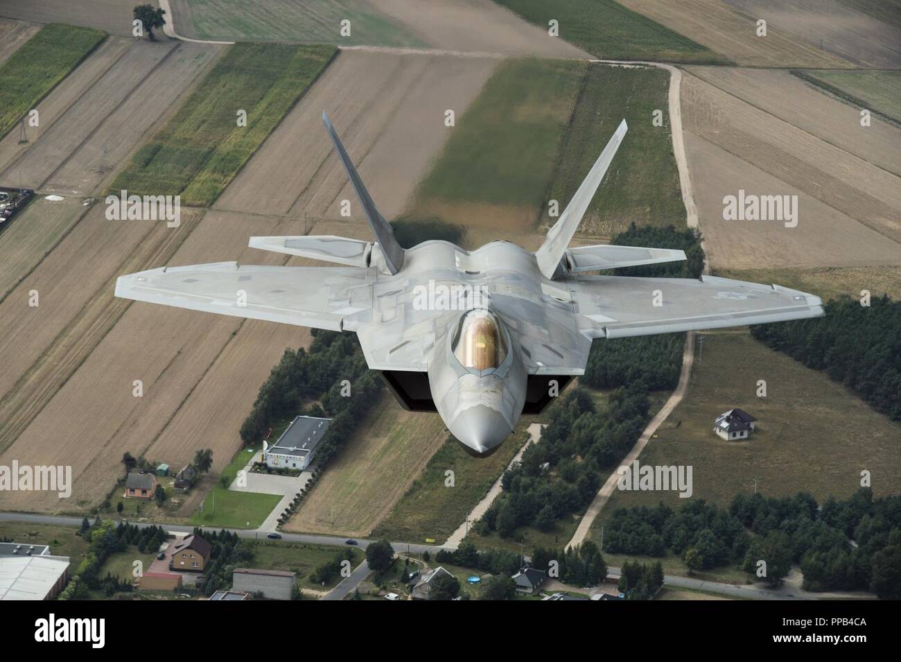 An F-22 Raptor from the 95th Fighter Squadron, 325th Fighter Wing, Tyndall Air Force Base, Fla., participate in a multi-aircraft flyover in Warsaw, Poland during the 100th Anniversary of Polish Independence and Armed Forces Day. The F-22s forward deployed from Spangdahlem Air Base Germany, to Powidz  Air Base, Poland on Aug. 14 for theater familiarization and to conduct interoperability with Polish and NATO aircraft. Stock Photo