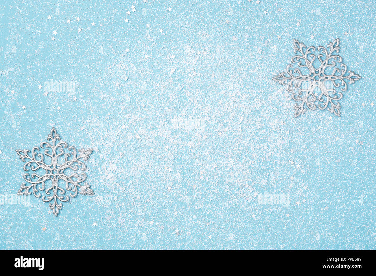 Light blue Christmas and New Year background with silver snowflakes. Winter holidays snowy card copy space. Stock Photo