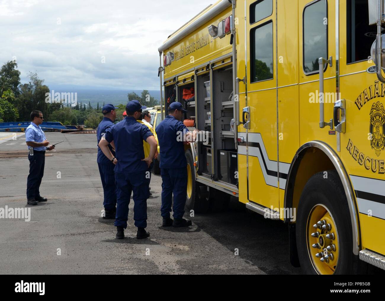 Members of the Coast Guard inspect a Hawaii County emergency vehicle at