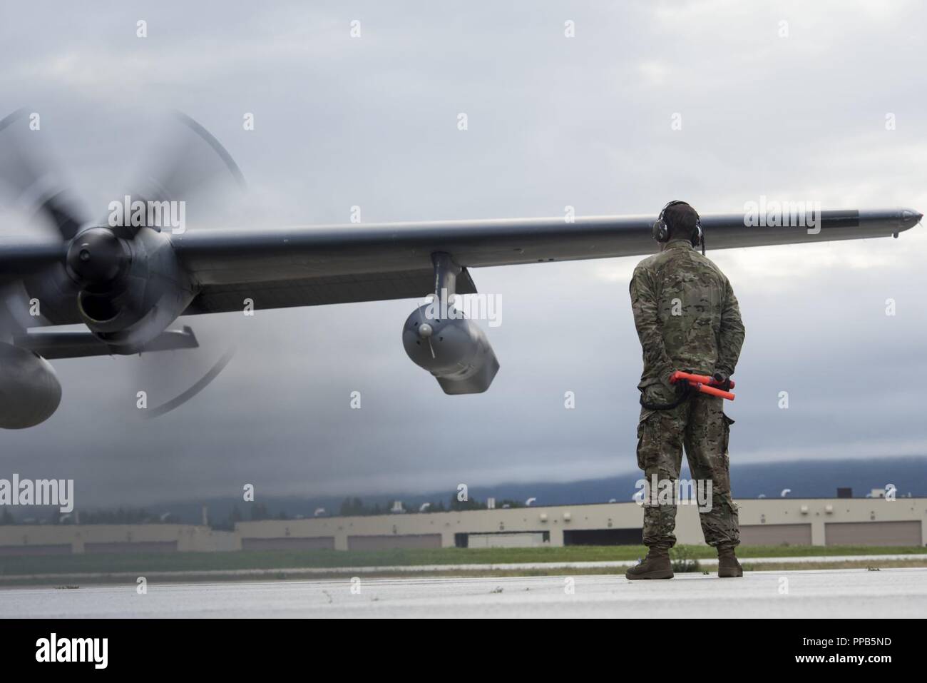 U.S. Air Force Staff Sgt. Joshua Hoffman, a 353rd Special Operations Maintenance Squadron crew chief from Kadena Air Force Base, Japan, prepares to marshal a U.S. Air Force MC-130H Combat Talon ll during Red Flag-Alaska 18-3 at Joint Base Elmendorf-Richardson, Alaska, Aug 16, 2018. RF-A is a Pacific Air Forces-directed field training exercise for U.S. and international forces flown under simulated air combat conditions. The exercises are focused on improving the combat readiness of U.S. and international forces and providing training for units preparing for air expeditionary force taskings. Stock Photo