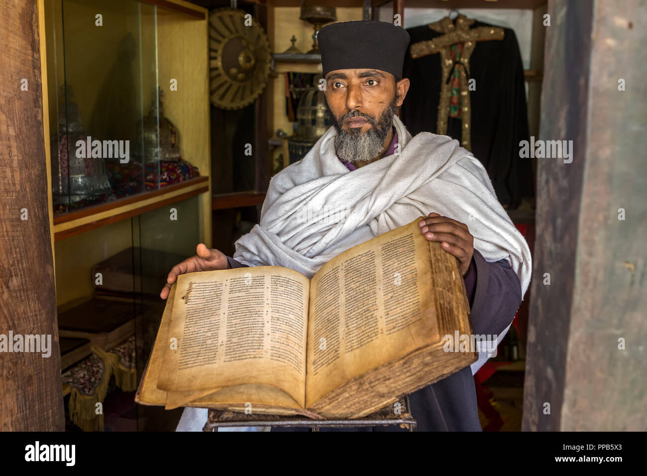 Priest with 1000 year old bible,Azua Mariam, The Painted House, monastery, Zenge Peninsula, Lake Tana, Ethiopia Stock Photo