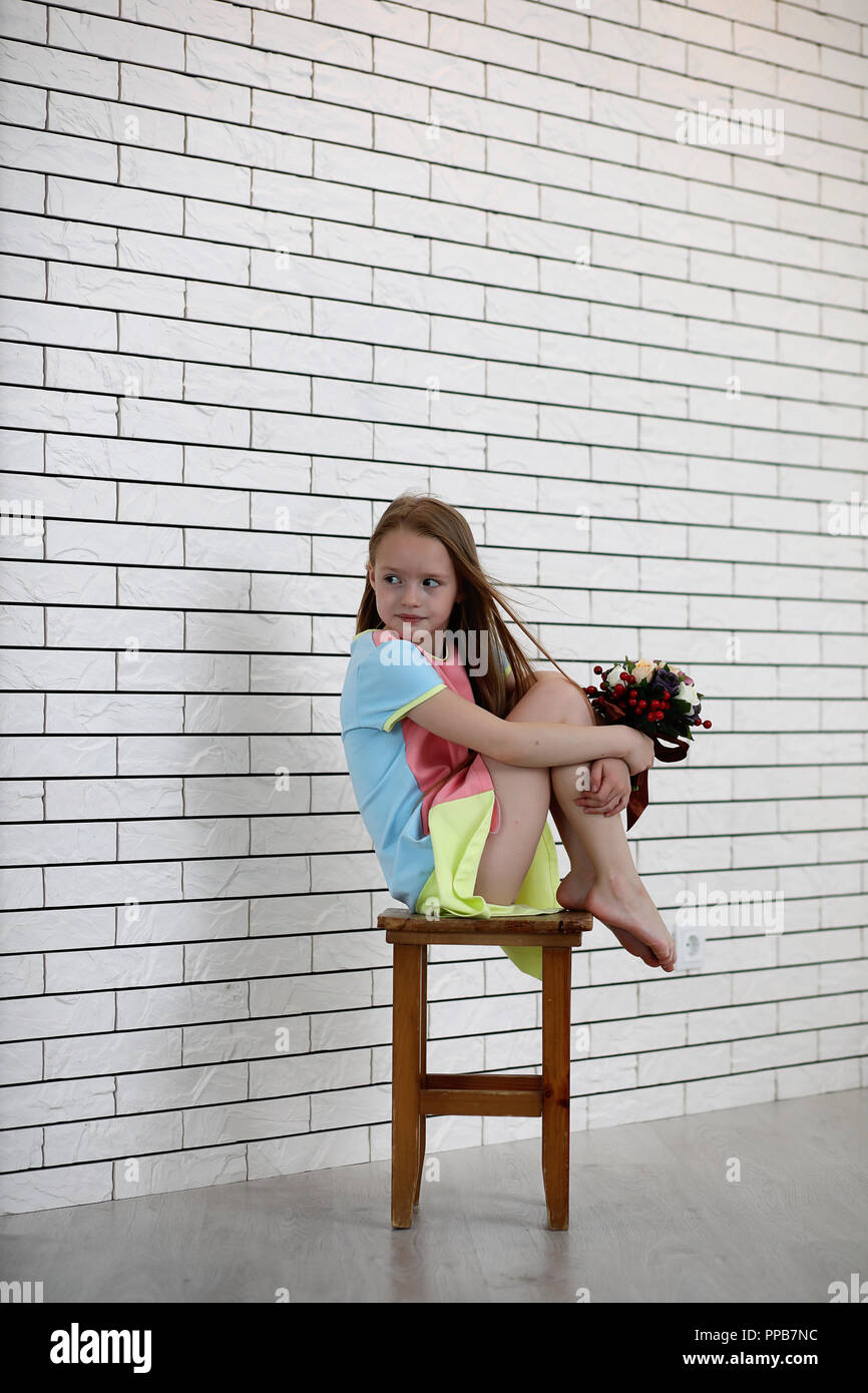 little girl is sitting on a chair Stock Photo - Alamy