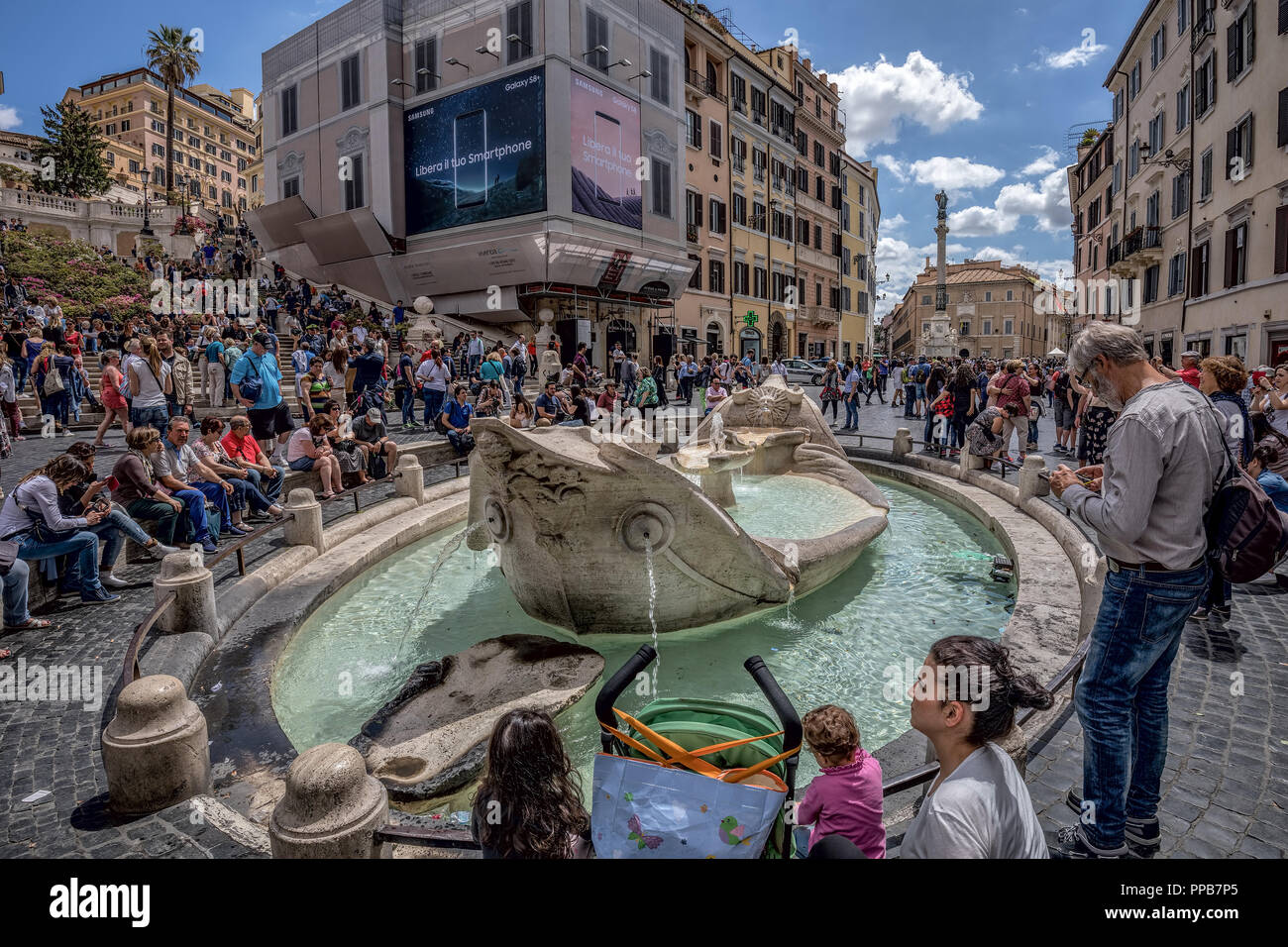 Crowded Piazza di Spagna surrounding the Fontana della Barcaccia Stock Photo