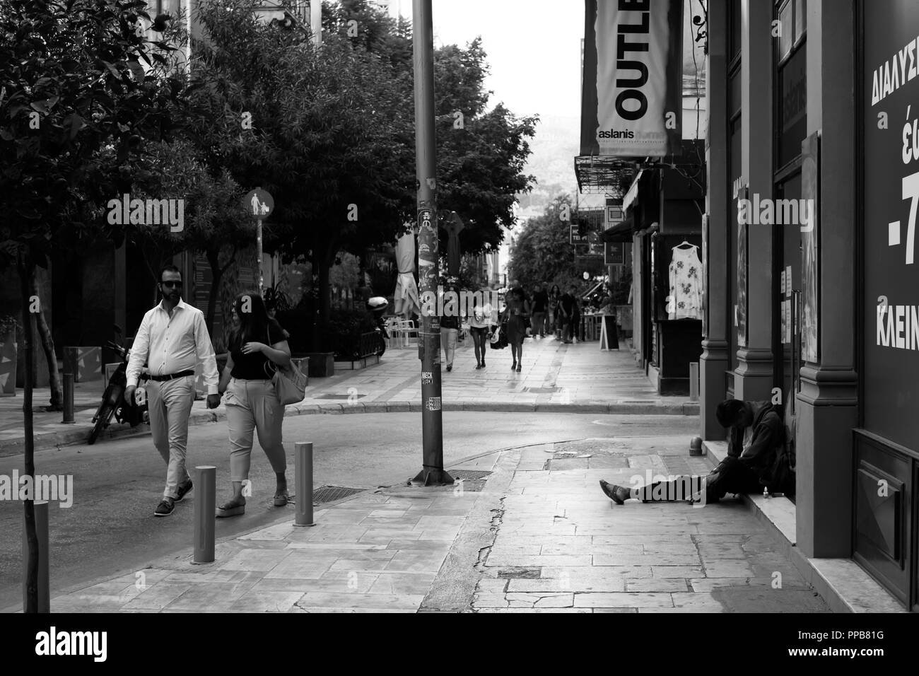 People walking by a homeless person, in downtown Athens, Greece Stock ...